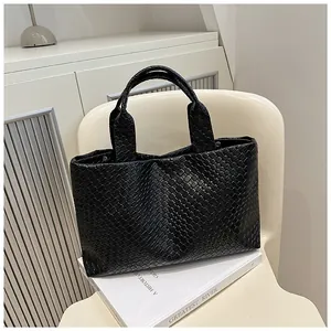 Detailed close-up of a black woven bucket bag showing intricate Intrecciato craftsmanship