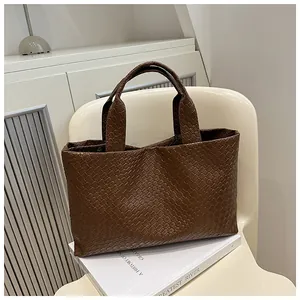 Close-up of the dark brown Intrecciato woven leather pattern on this spacious tote bag