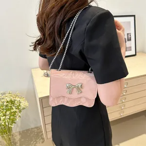 Pink wavy shoulder bag with silver bow accent and metallic chain strap for women