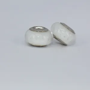 Macro shot of white glass beads with delicate bubbles and silver metal tube core