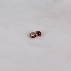 Detailed macro view of 14mm resin beads with red floral patterns and silver cores