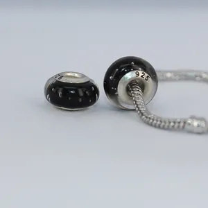Macro shot showing 925 silver stamp on black glass bubble charm beads for DIY bracelets