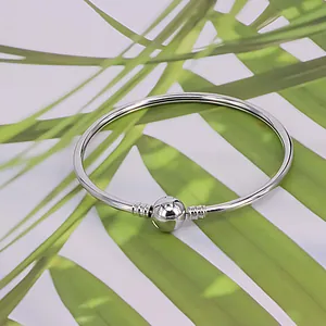 Bracelet jonc rond argenté poli avec fermoir sphérique et détails de texture spirale