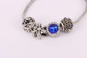 Détail du bracelet chaîne serpent en argent avec cristaux bleus et breloques étoiles