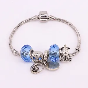 Bracelet serpent argenté avec chouette, licorne et perles en cristal bleu sur blanc