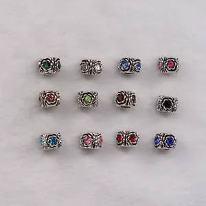 Detail of 12 vintage rose charms in antique silver with colorful rhinestones on fur