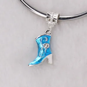 Blue enamel boot charm with crystal accents on a silver bracelet with white fur background