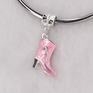 Close-up of pink enamel boot charm with embossed texture and sparkling crystal accent