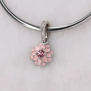 Macro shot of pink enamel flower charm with silver crystal pavé bail on plush background