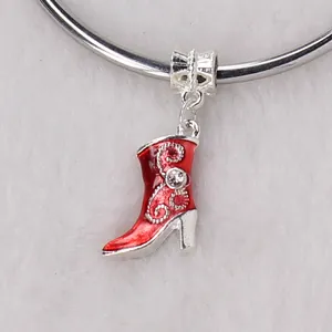 Detail shot of red enamel boot charm with silver spiral pattern and sparkling rhinestone
