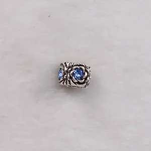 Detailed view of silver rose petal bead charm with blue crystal for DIY jewelry