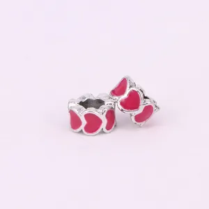 Macro detail of silver alloy heart-shaped beads with pink enamel for DIY jewelry making