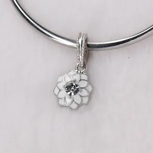 Macro detail of silver floral charm with white enamel petals and center rhinestone