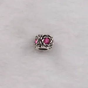 Detailed view of silver rose bead charm with pink crystal inlay and openwork design