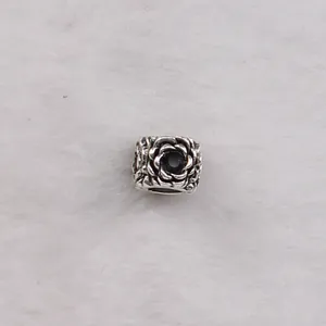 Detail of flower charm bead with layered petals and a black center for DIY bracelets
