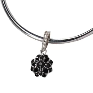 Silver flower pendant with black enamel petals and crystal center on a metal charm ring