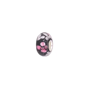 Macro shot of glass charm bead with pink flower patterns and metal core for DIY bracelets