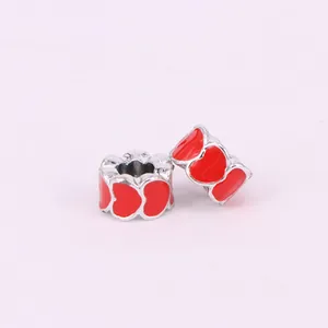 Macro view of two silver heart-shaped enamel beads for DIY jewelry bracelet making