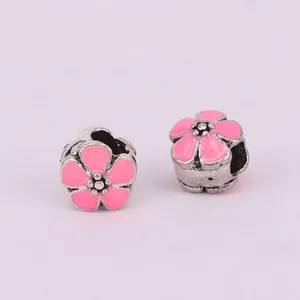 Detailed view of pink cherry blossom charms with enamel finish for DIY jewelry making