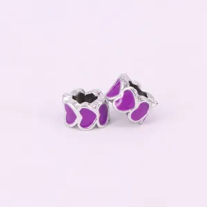 Macro view of silver hollow charms with purple enamel heart patterns for DIY bracelets