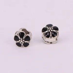 Detail of vintage-style flower beads with black enamel and silver-colored metal alloy core