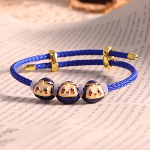 Bracciale intrecciato blu con perline smaltate e chiusura regolabile in metallo dorato