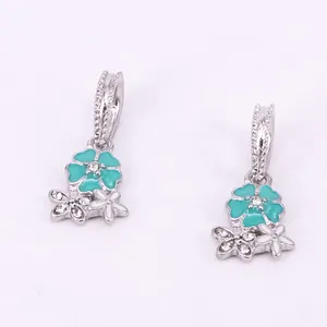 Macro detail of cherry blossom pendants with teal enamel and sparkling rhinestones