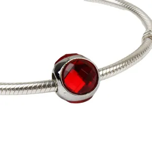 Silver snake chain bracelet featuring a brilliant red faceted crystal drop bead