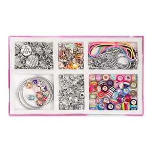 Flat lay of pink jewelry box with DIY charm bracelet kit featuring colorful beads and charms
