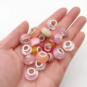 Macrodetail van diverse roze hars- en glasparels met zilveren kern voor DIY-armbanden