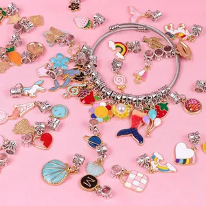 DIY jewelry set detail featuring unicorn enamel charms and a silver coil bracelet