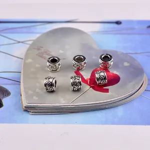 Close-up of vintage carved metal cylinder beads for DIY jewelry making sets