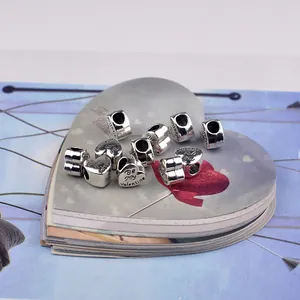 Macro shot of silver heart charms with Be My Valentine engraving for jewelry making