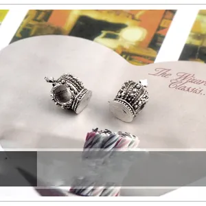 Detailed macro view of two vintage silver crown charms for DIY jewelry crafting