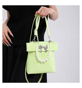 Detail showing lime green bow handbag with large pearl handle and silver metallic buckle