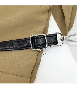 Detail view of the adjustable black shoulder strap with silver metal buckle on a khaki bag