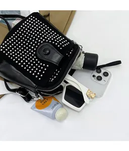 Detail showing the spacious interior of the black rhinestone crossbody bag with daily items