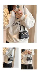 Detailopname van zwarte leren tas met een fonkelende diamanten strik en ketting
