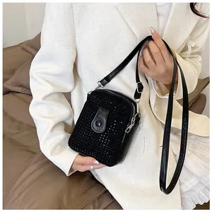 Close-up of black rhinestone mini crossbody bag worn with a white blazer for a stylish look