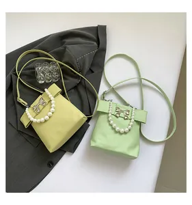 Detail of lime yellow and mint green handbags with bow decor and pearl handles