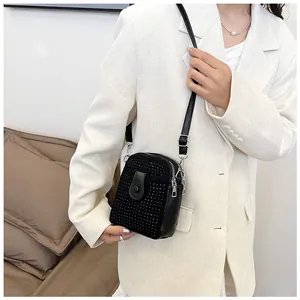 Detailed view of mini rhinestone crossbody bag with silver studs and chain strap
