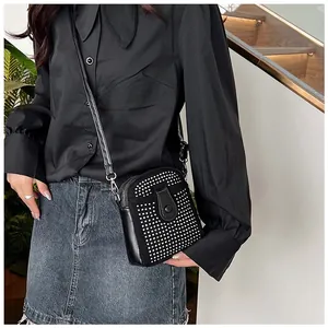 Detailed view of a mini black rhinestone crossbody bag with elegant chain strap on a model