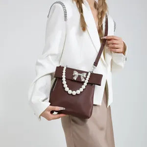 Chic dark brown shoulder bag with silver bow and elegant faux pearl handle for women