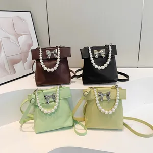Chic women's pearl handle crossbody bag with metallic bow in four fashion colors