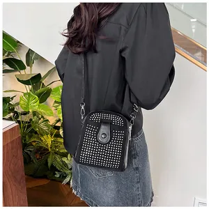 Close-up of a black mini crossbody bag with silver rhinestones on a female model