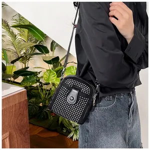 Close-up detail of mini crossbody bag with silver rivet studs and metal zipper