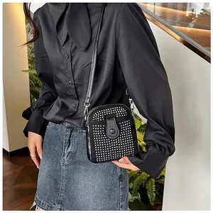 Detailed view of the black crossbody bag featuring silver stud matrix on faux leather