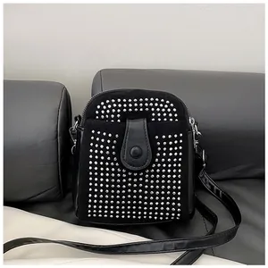 Close-up of black rhinestone crossbody bag with studs and leather snap closure
