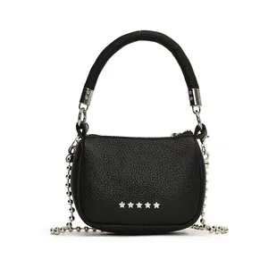 Dettaglio mini borsa in pelle nera con stelle argentate e tracolla a catena a sfere