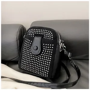 Detail of black crossbody phone bag with sparkling silver rhinestones and double zippers